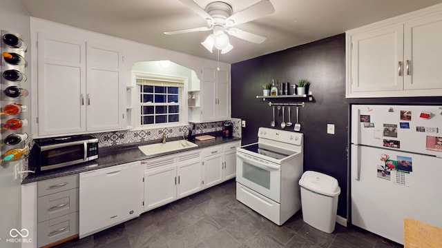 kitchen with white appliances, a sink, white cabinets, open shelves, and dark countertops