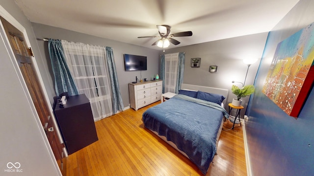 bedroom with wood-type flooring, ceiling fan, and baseboards