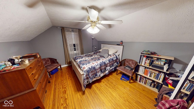 bedroom featuring a textured ceiling, ceiling fan, wood finished floors, and lofted ceiling