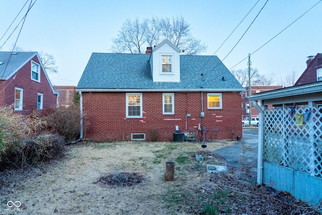 back of house featuring crawl space, roof with shingles, a chimney, and brick siding