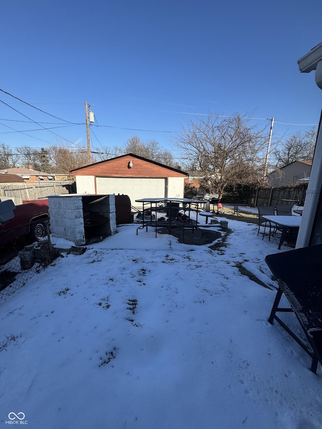 yard layered in snow with a fenced backyard and an outbuilding