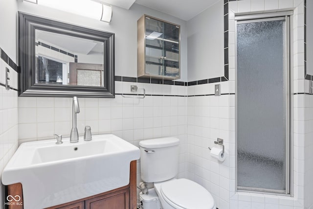 full bathroom featuring a stall shower, toilet, tile walls, and a sink