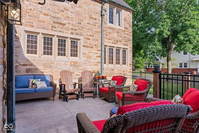 view of patio with an outdoor living space and fence