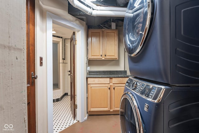 washroom with cabinet space and stacked washer / drying machine