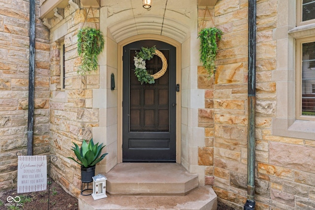 property entrance with stone siding and brick siding