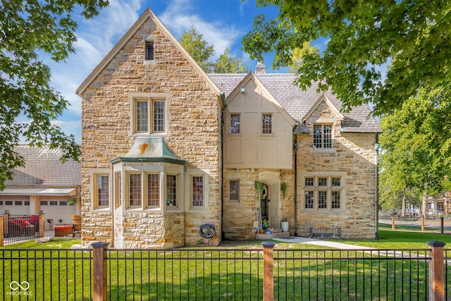 view of front of property with a fenced front yard, stone siding, and a front lawn