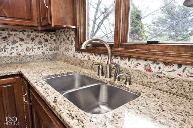 details with light stone countertops and a sink