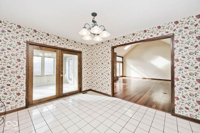 tiled empty room featuring a notable chandelier, baseboards, and wallpapered walls