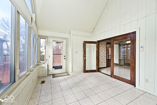 unfurnished sunroom featuring a wealth of natural light, visible vents, and vaulted ceiling