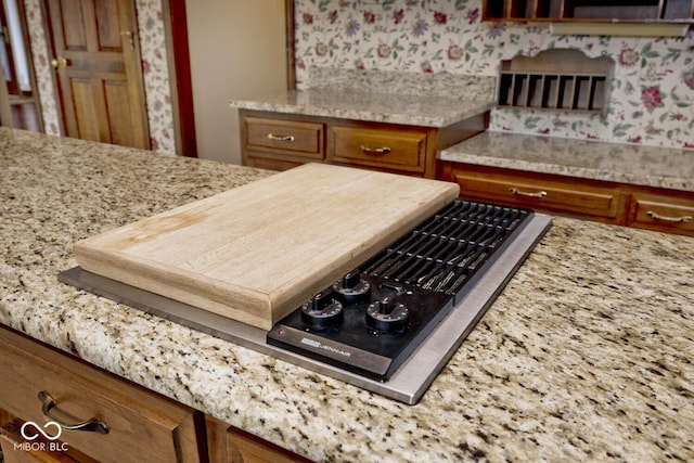 kitchen with light stone countertops and brown cabinetry