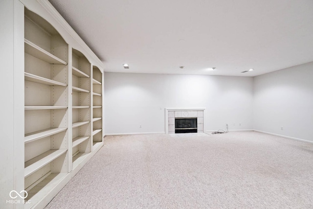 unfurnished living room featuring carpet, a fireplace, and baseboards