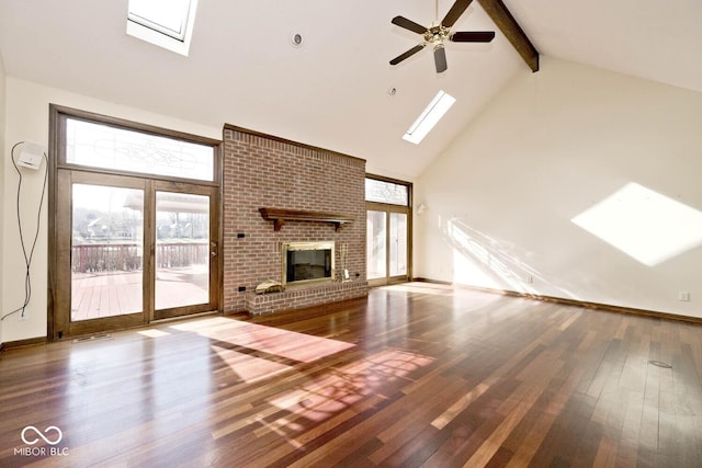 unfurnished living room featuring high vaulted ceiling, a skylight, a brick fireplace, hardwood / wood-style floors, and beamed ceiling