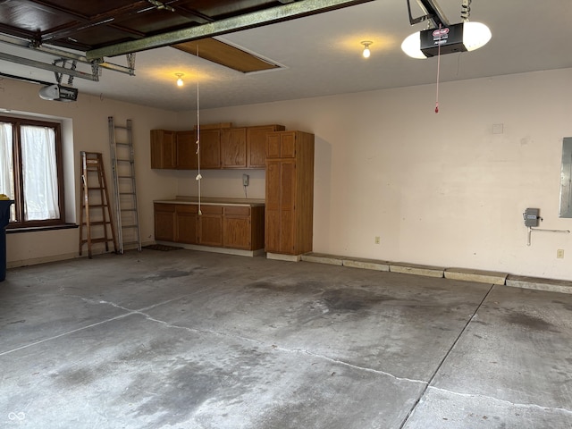 garage with baseboards, electric panel, and a garage door opener