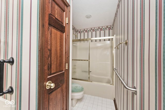 full bath with a textured ceiling, toilet, combined bath / shower with glass door, tile patterned floors, and wallpapered walls