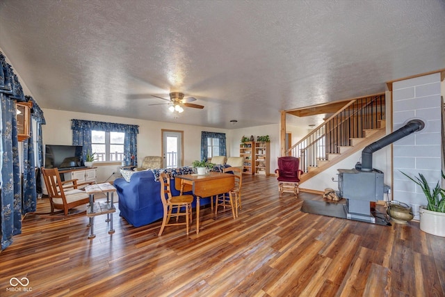 living room featuring stairs, ceiling fan, a textured ceiling, and wood finished floors