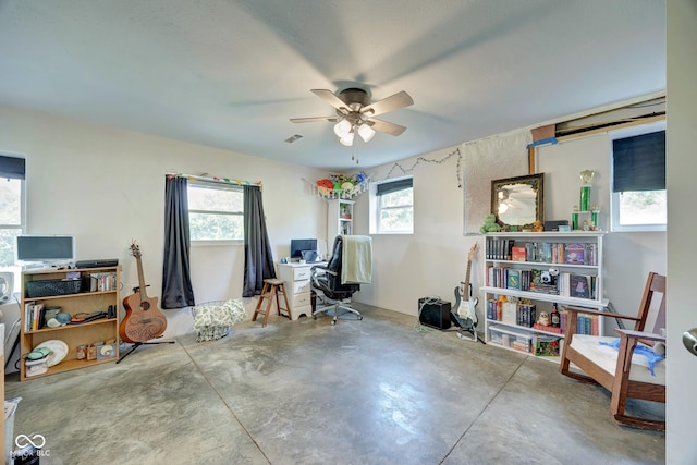 office area featuring visible vents, concrete floors, and a ceiling fan