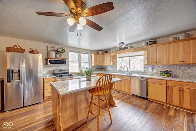 kitchen with light wood finished floors, open shelves, appliances with stainless steel finishes, and decorative backsplash