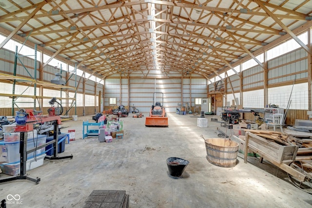 misc room with lofted ceiling, a workshop area, and metal wall