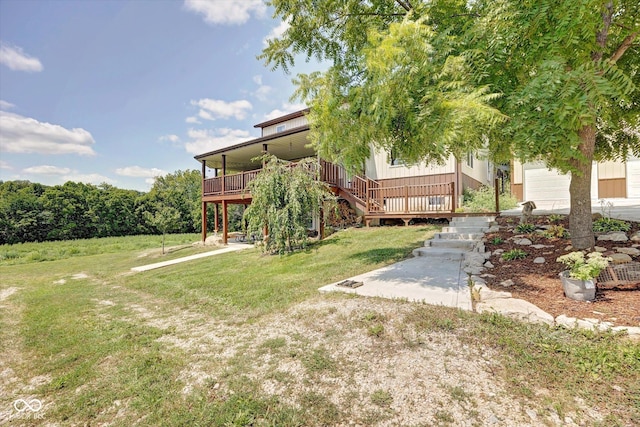 view of yard with a garage, stairway, and a wooden deck