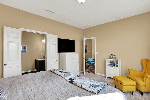 carpeted bedroom featuring visible vents, baseboards, and a textured ceiling