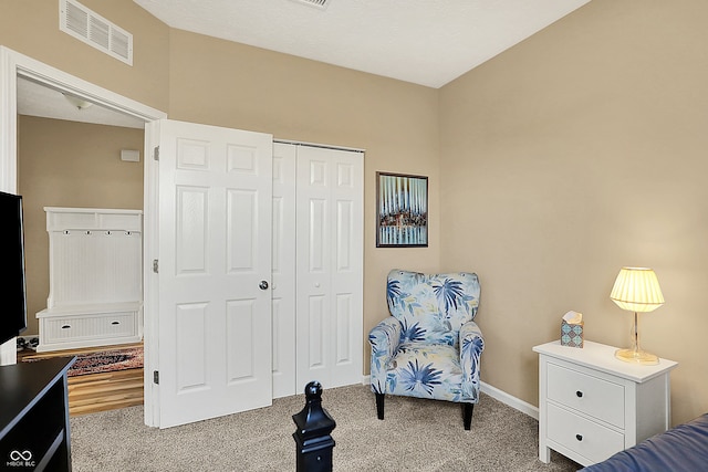 carpeted bedroom with baseboards, visible vents, and a closet