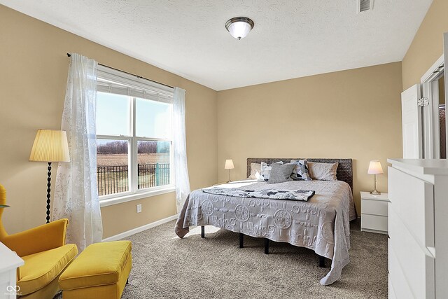 carpeted bedroom with baseboards and a textured ceiling