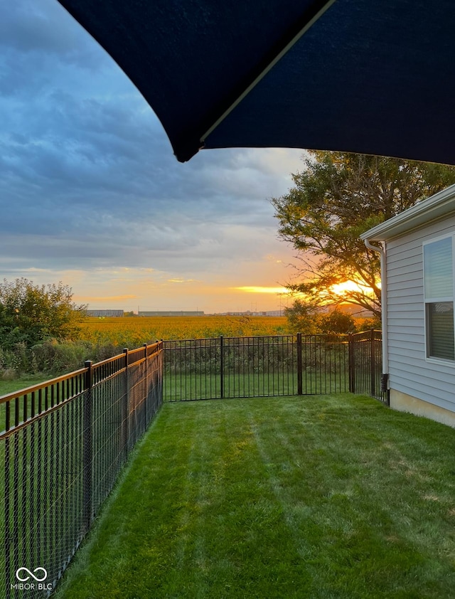 yard at dusk with a fenced backyard