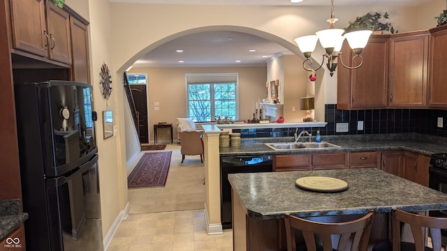 kitchen with tasteful backsplash, ornamental molding, a peninsula, black appliances, and a sink