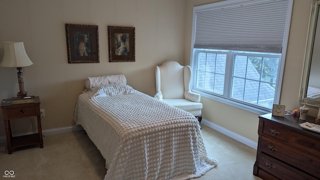 bedroom featuring light carpet and baseboards