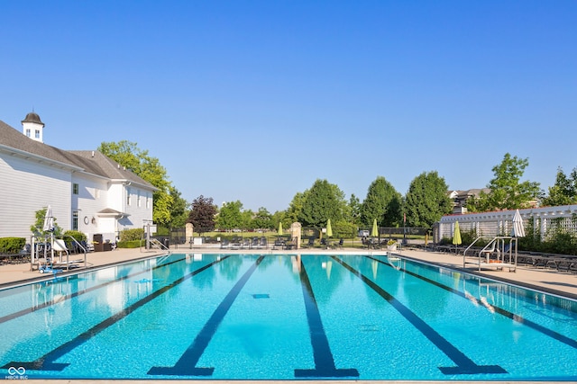 pool with a patio area and fence