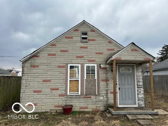 view of front facade with fence private yard and stone siding