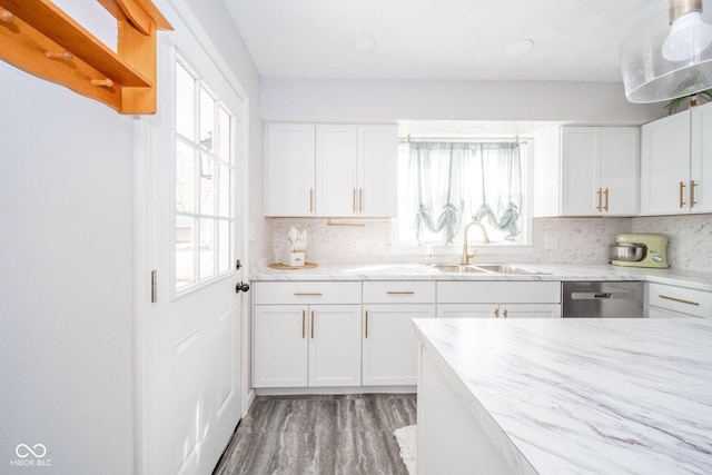 kitchen with stainless steel dishwasher, a sink, white cabinetry, and a healthy amount of sunlight