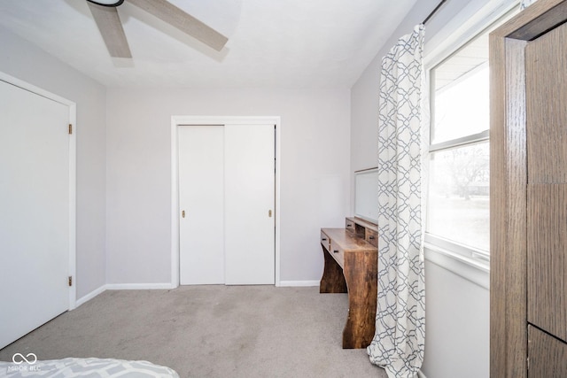 carpeted bedroom featuring a closet, a ceiling fan, and baseboards