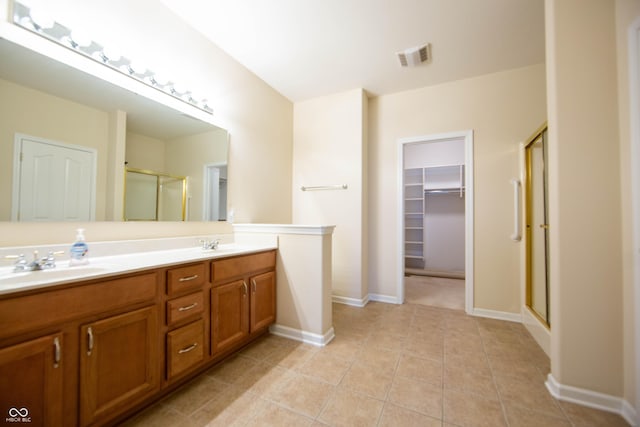 full bath with double vanity, visible vents, tile patterned flooring, a shower stall, and a sink