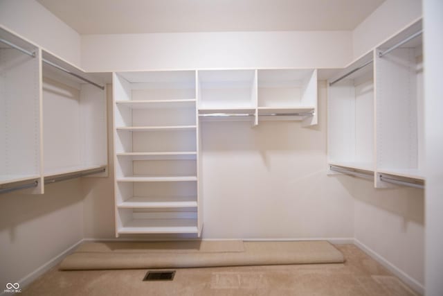 walk in closet featuring visible vents and carpet floors