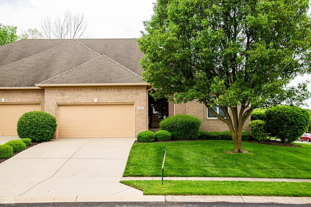 view of front of home with a shingled roof, an attached garage, a front lawn, brick siding, and driveway
