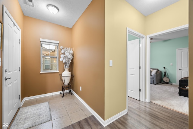 foyer with visible vents, baseboards, and light tile patterned flooring