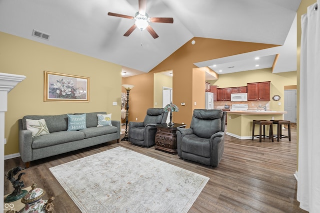 living room featuring baseboards, visible vents, ceiling fan, wood finished floors, and high vaulted ceiling