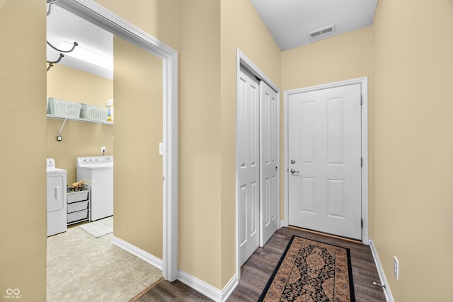 entryway with visible vents, baseboards, and separate washer and dryer