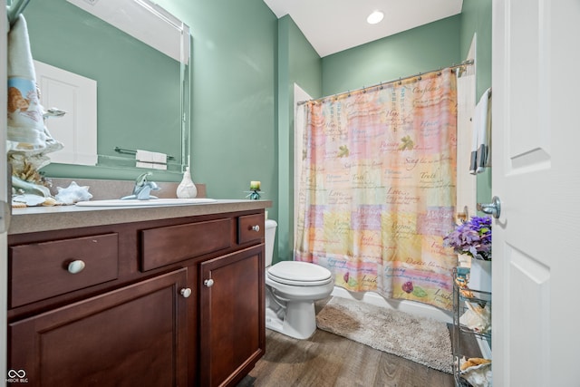 full bathroom featuring toilet, shower / bathtub combination with curtain, wood finished floors, and vanity