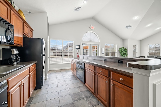 kitchen featuring black appliances, a wealth of natural light, dark countertops, and visible vents