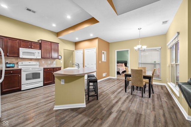 kitchen featuring white appliances, visible vents, decorative backsplash, and a sink