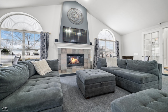 living area with high vaulted ceiling, carpet, and a tiled fireplace