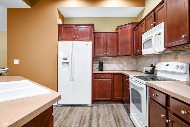 kitchen with white appliances, light wood-style floors, light countertops, dark brown cabinets, and backsplash