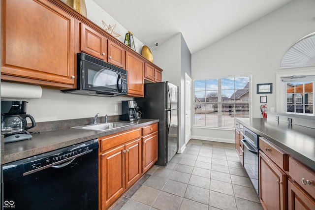 kitchen with brown cabinets, dark countertops, lofted ceiling, a sink, and black appliances