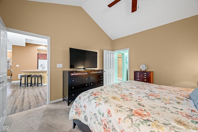 bedroom featuring ceiling fan, high vaulted ceiling, carpet floors, white refrigerator with ice dispenser, and baseboards