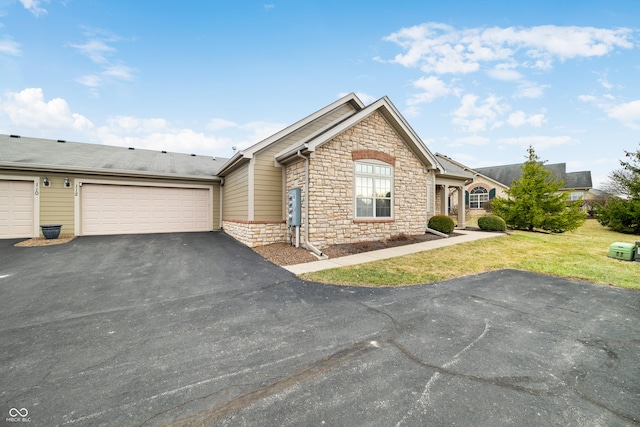 view of front of home with a garage, stone siding, and a front yard