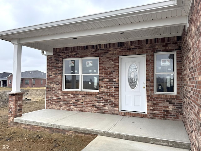 doorway to property with brick siding