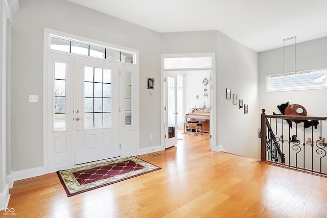 foyer entrance with light wood-style flooring and baseboards