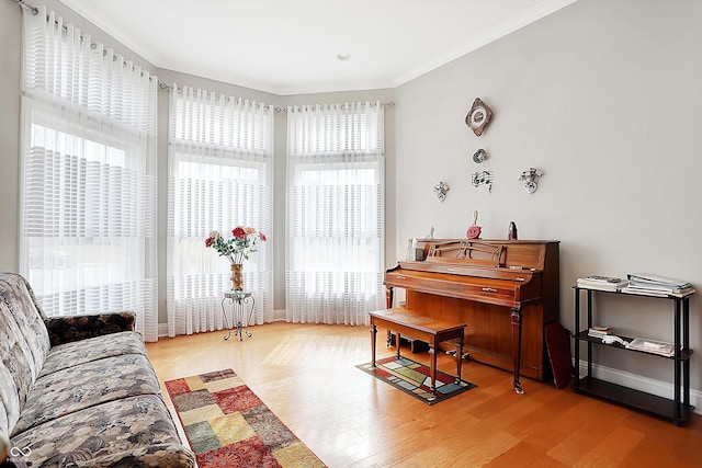 sitting room featuring baseboards, ornamental molding, and wood finished floors